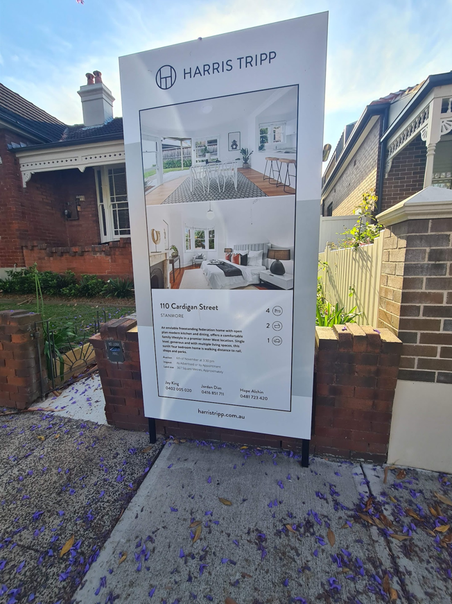 Sydney family standing outside their new home with a for-sale sign on the old one